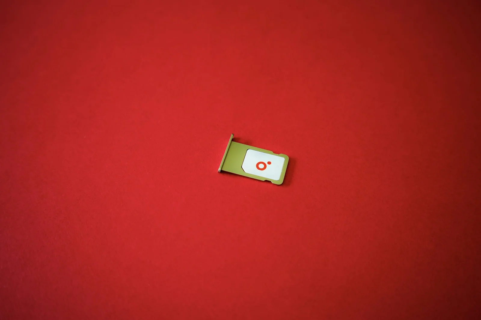 Carte SIM et son tiroir sur un fond rouge