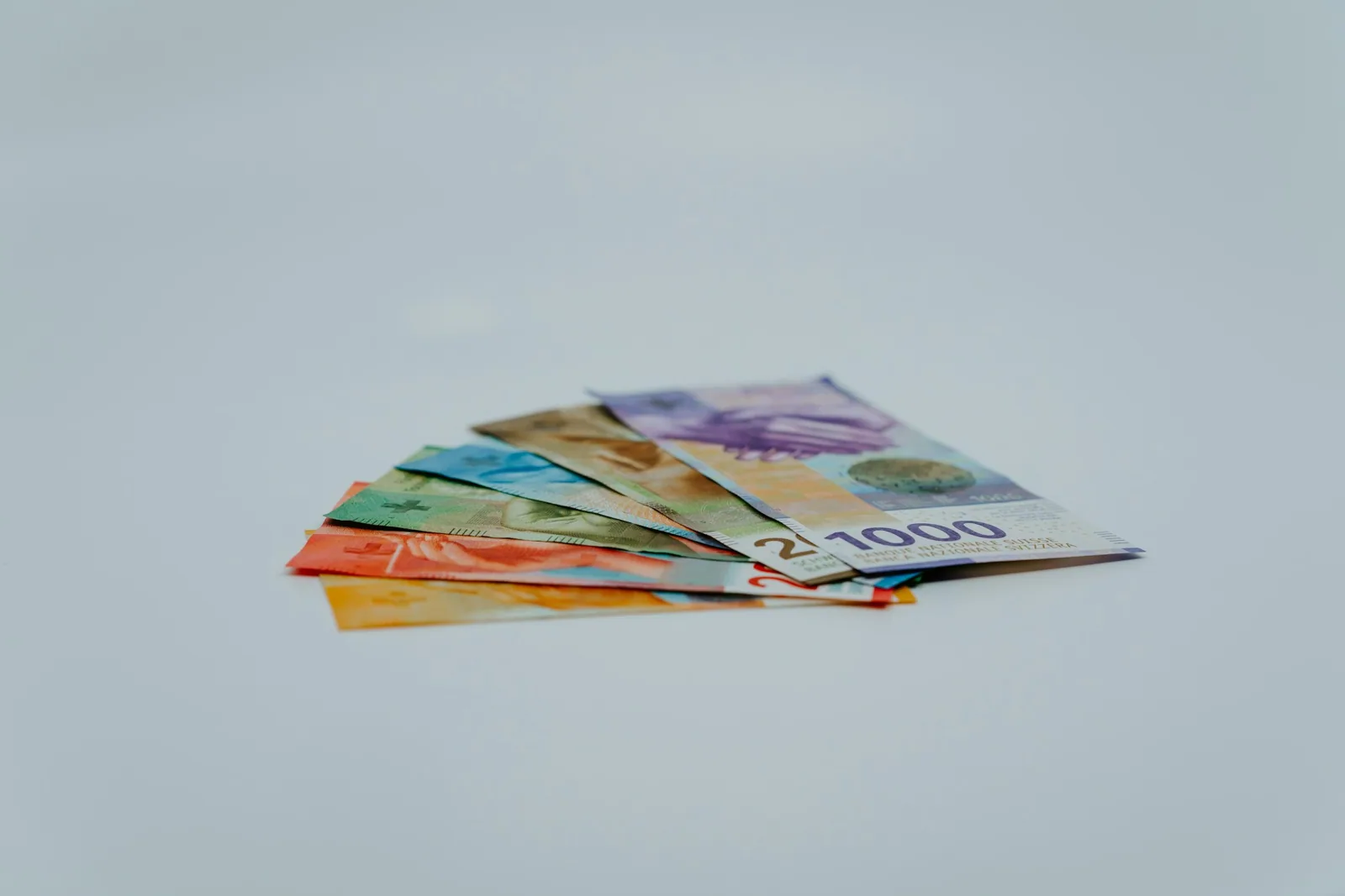 Billets suisses superposés sur une surface claire.