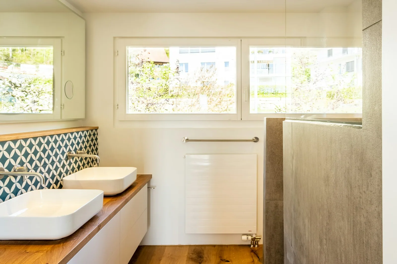 Salle de bain rénovée avec double vasque et fenêtre à Zürich.