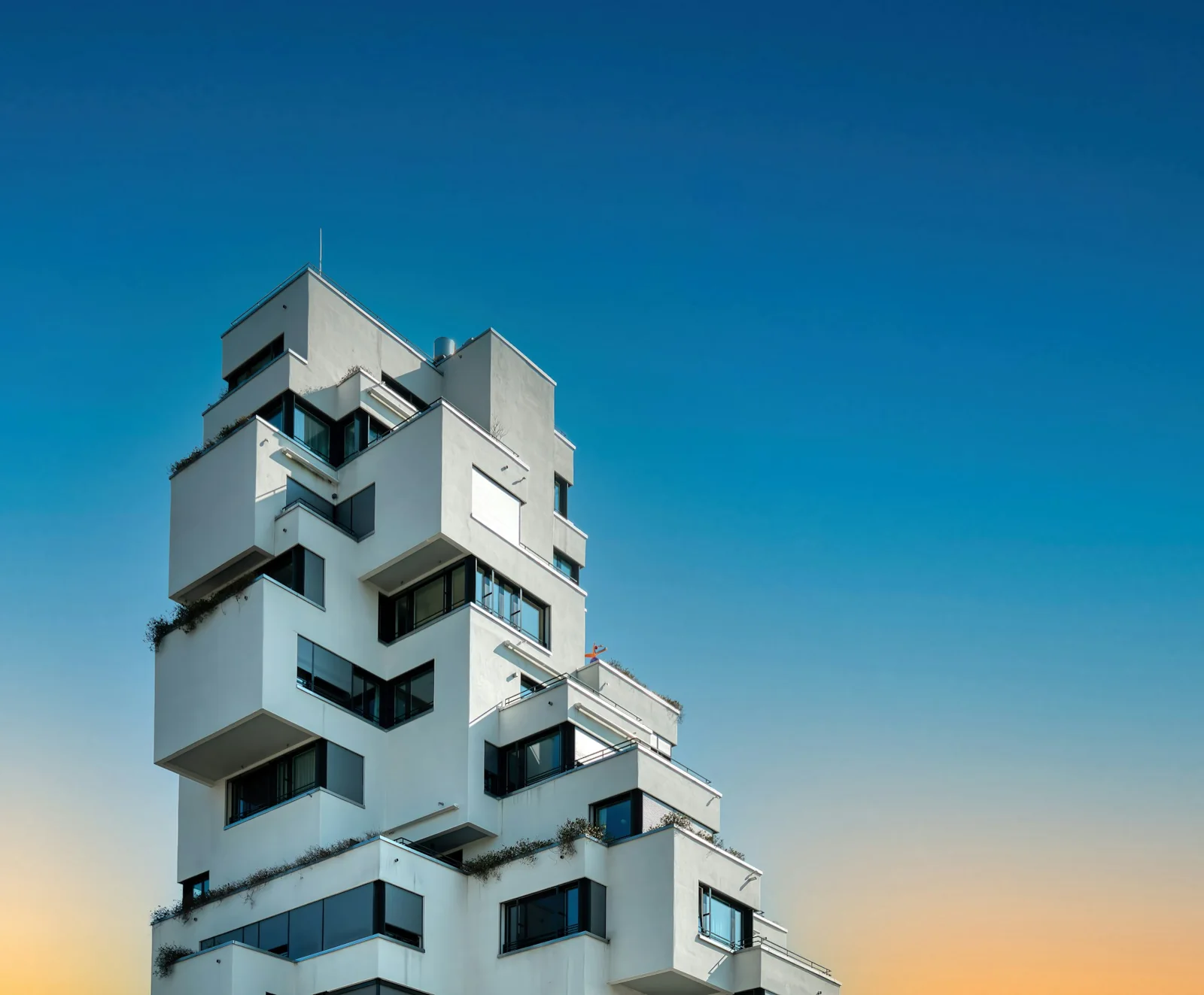 Tour résidentielle Stollturm à Bâle, aux balcons blancs géométriques sous un ciel bleu.