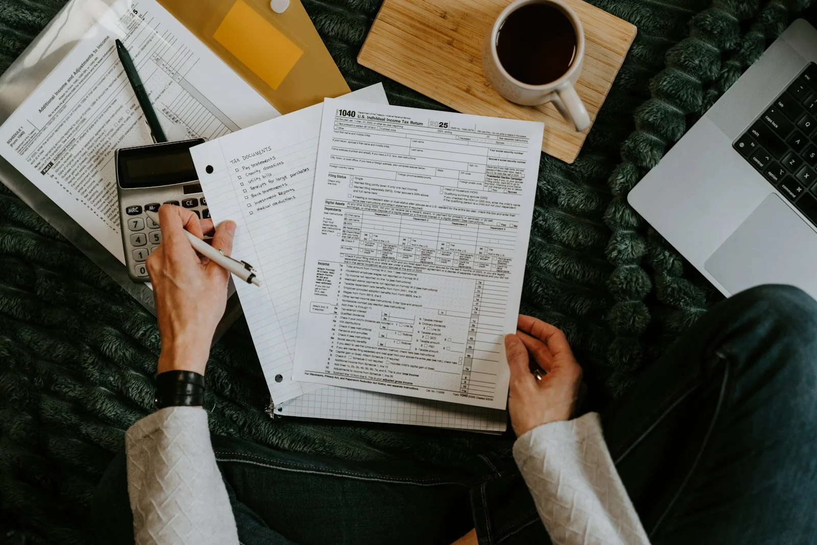 Une personne examine ses documents à côté d’une calculatrice.