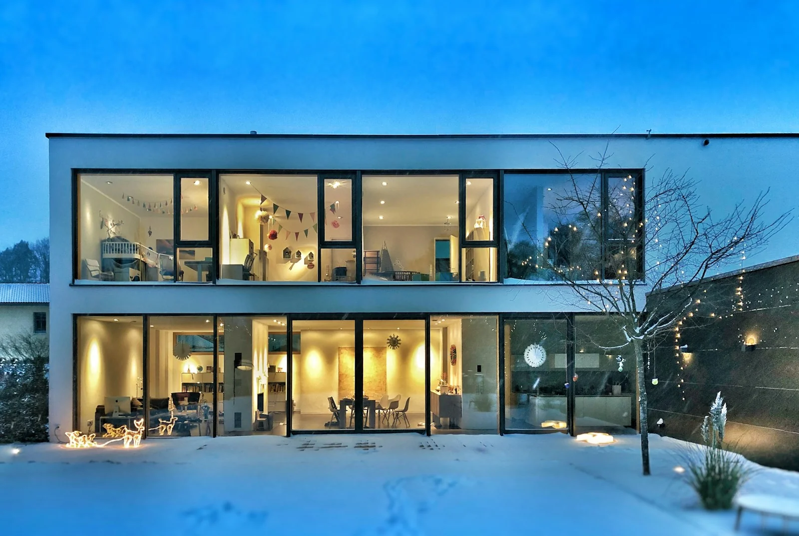 Maison contemporaine aux grandes baies vitrées en hiver.