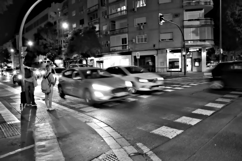 Voitures à un carrefour photographié en noir et blanc.