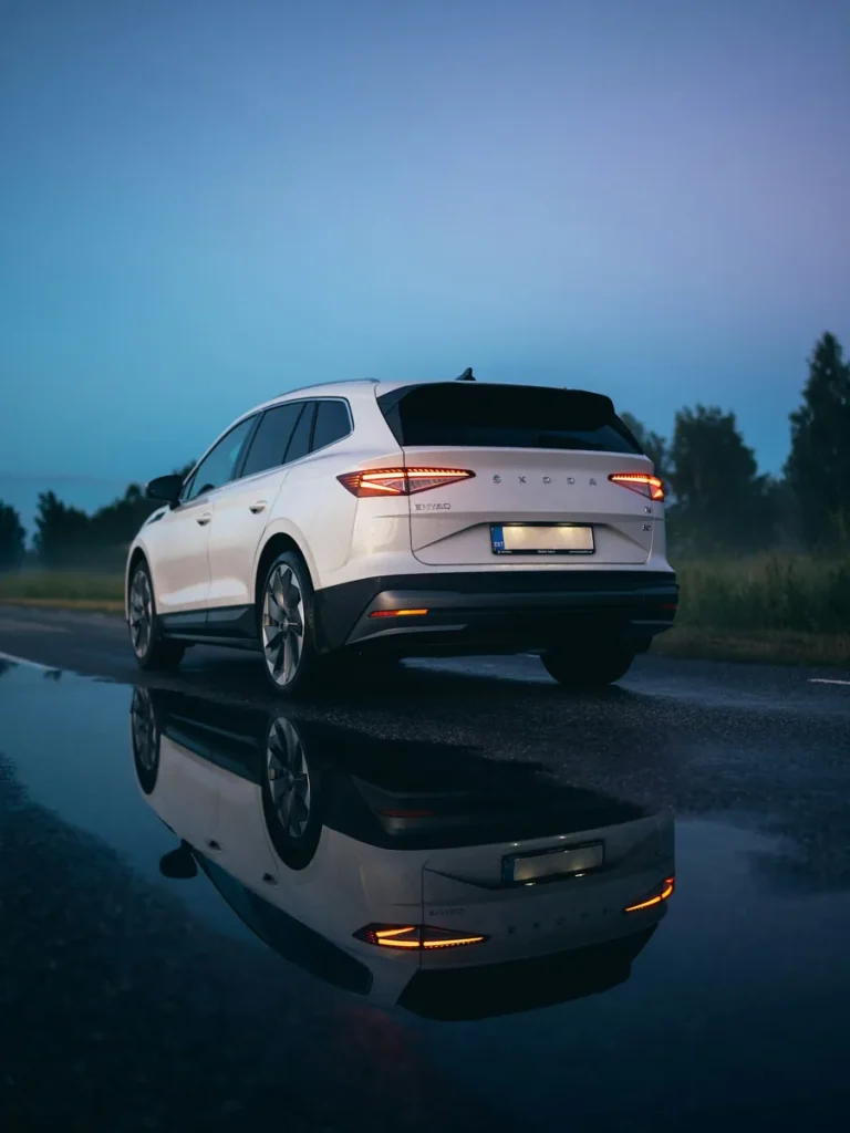 Voiture blanche vue de l’arrière sur une route.