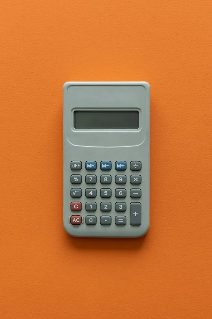 Calculatrice posée sur une table orange.