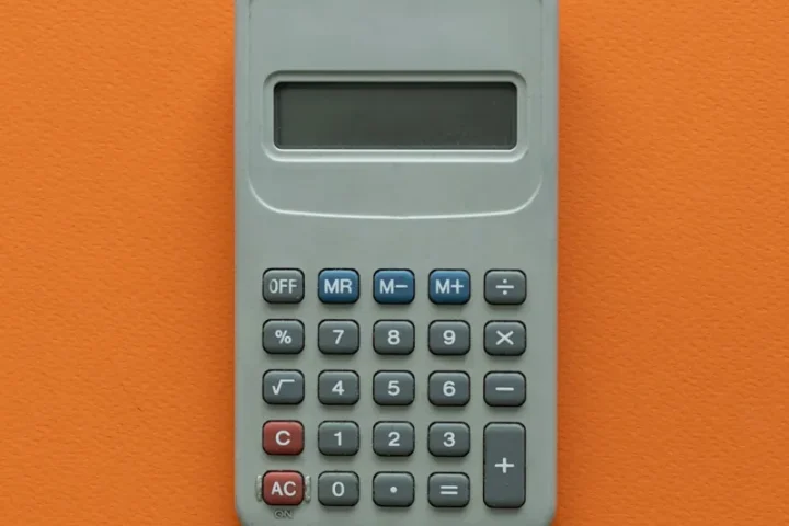 Calculatrice posée sur une table orange.