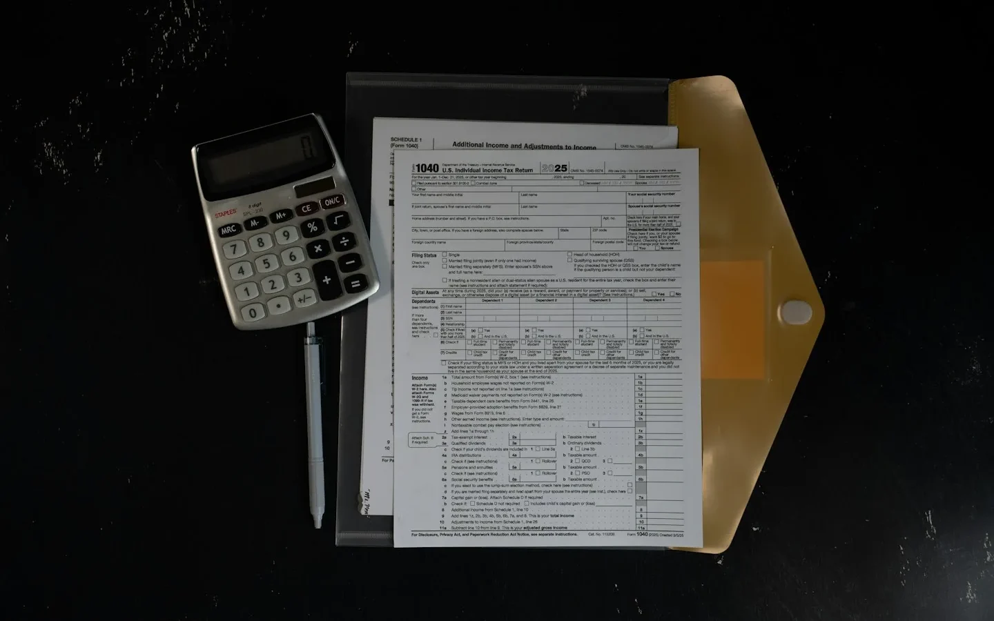 Calculatrice à côté de documents rangés dans une chemise.