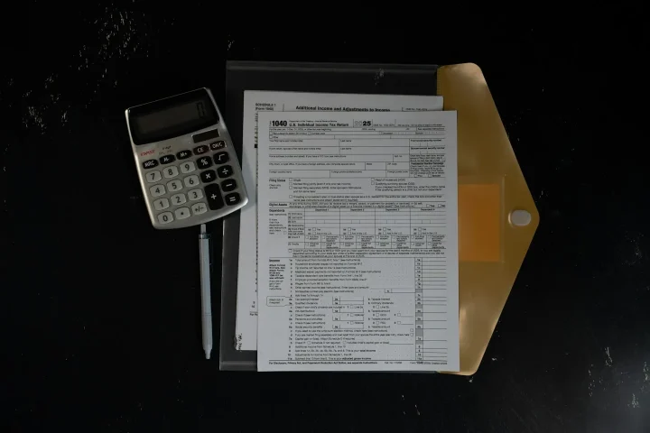 Calculatrice à côté de documents rangés dans une chemise.