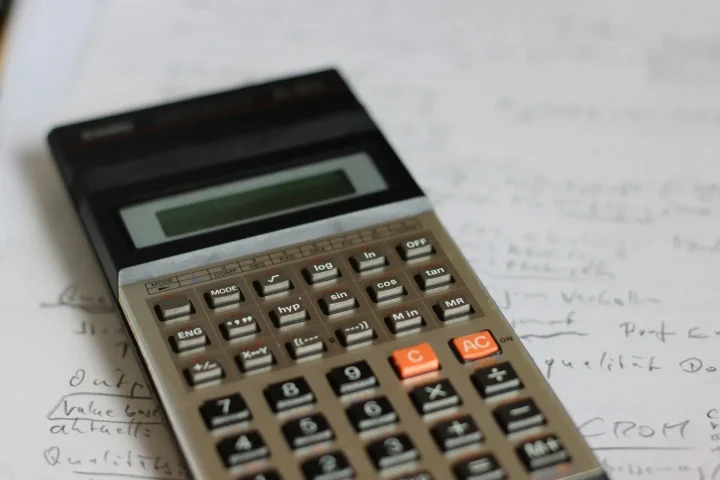 Calculatrice posée sur une feuille avec des notes.