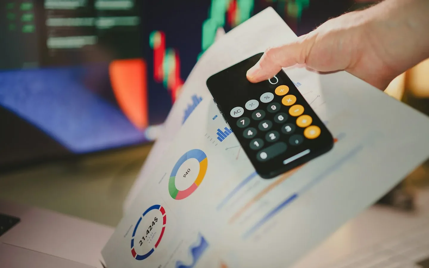 Une personne utilise une calculatrice au-dessus de graphiques imprimés.