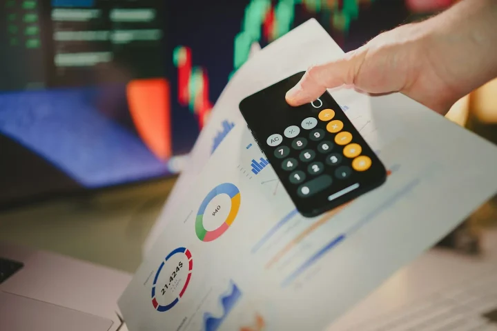 Une personne utilise une calculatrice au-dessus de graphiques imprimés.