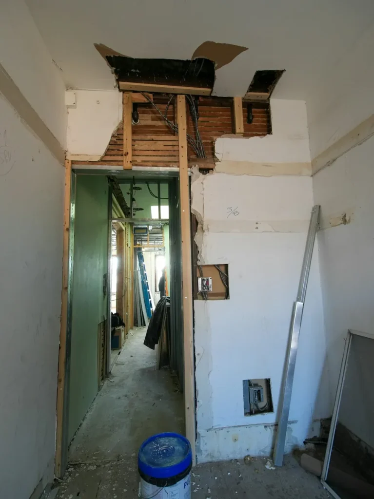 Cloisons ouvertes et structure visible dans une pièce en rénovation.