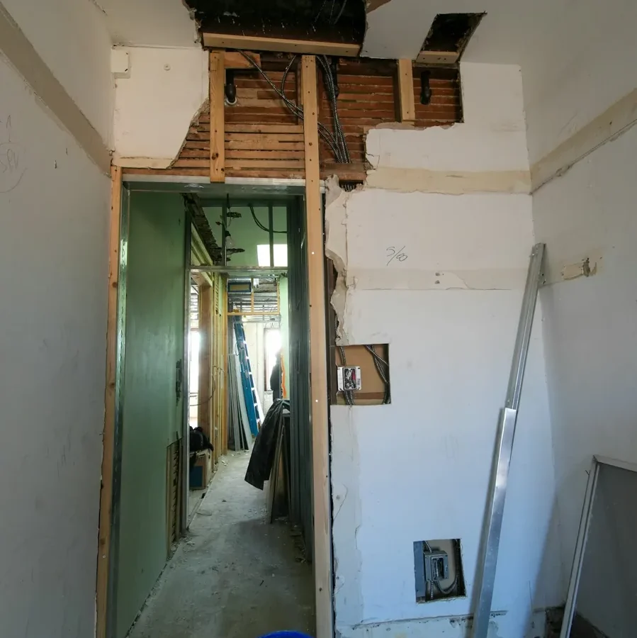 Cloisons ouvertes et structure visible dans une pièce en rénovation.