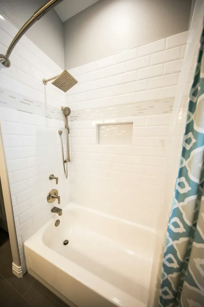 Baignoire et douche dans une salle de bain carrelée.