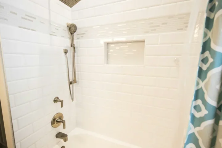Baignoire et douche dans une salle de bain carrelée.