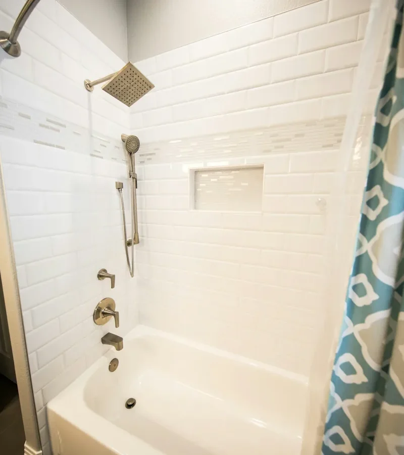 Baignoire et douche dans une salle de bain carrelée.