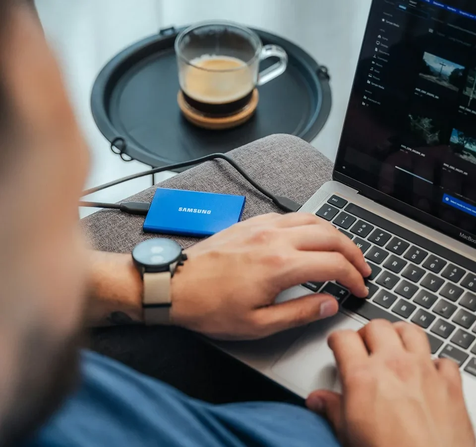 Ordinateur portable, disque externe et casque audio sur un bureau.