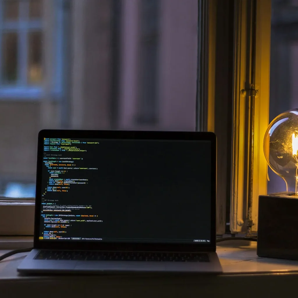 Ordinateur portable allumé sur un bureau près d’une fenêtre.