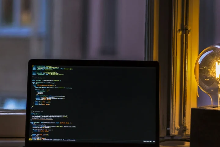 Ordinateur portable allumé sur un bureau près d’une fenêtre.