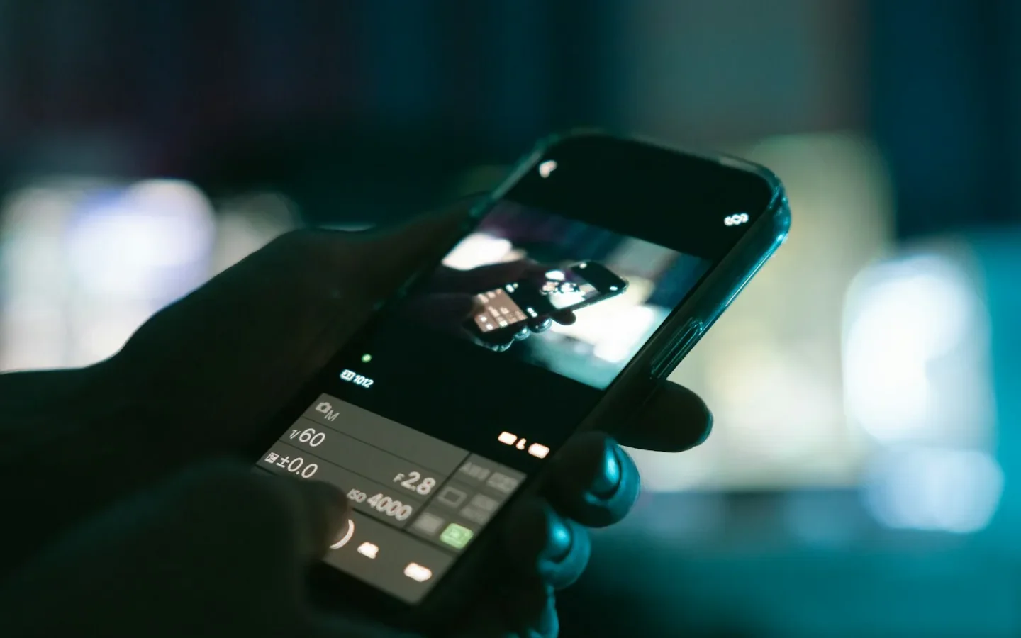 Smartphone tenu dans une main, application photo ouverte.