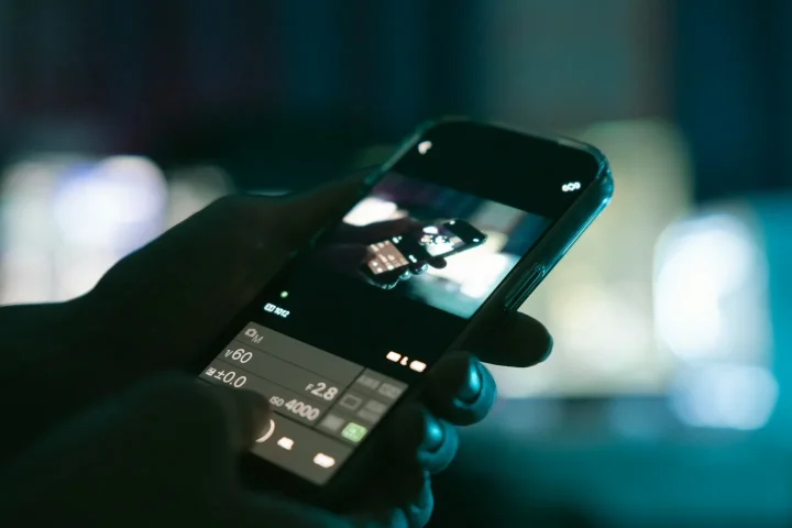 Smartphone tenu dans une main, application photo ouverte.