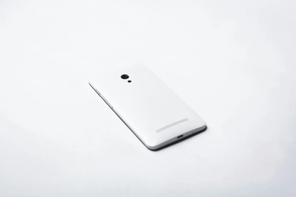 Dos d’un smartphone blanc posé sur une surface claire.