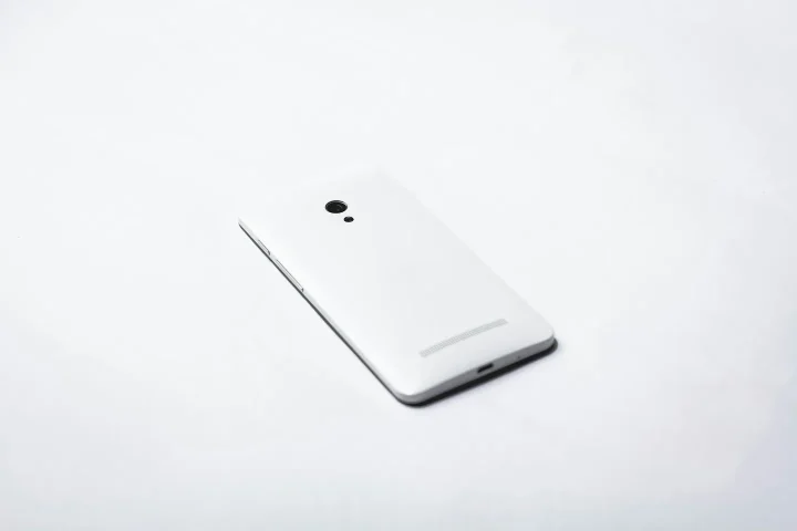 Dos d’un smartphone blanc posé sur une surface claire.